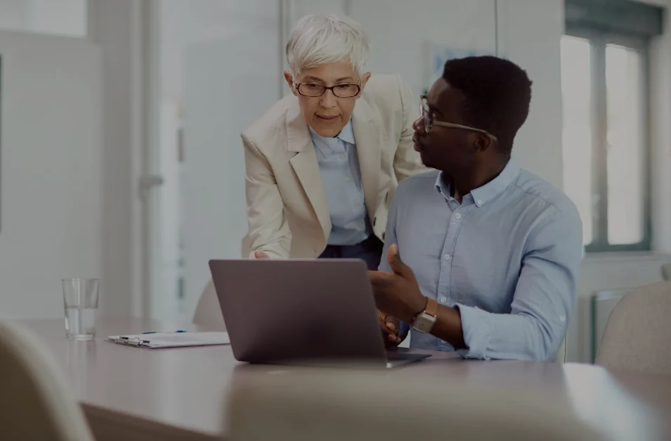 A person and person looking at a laptop
